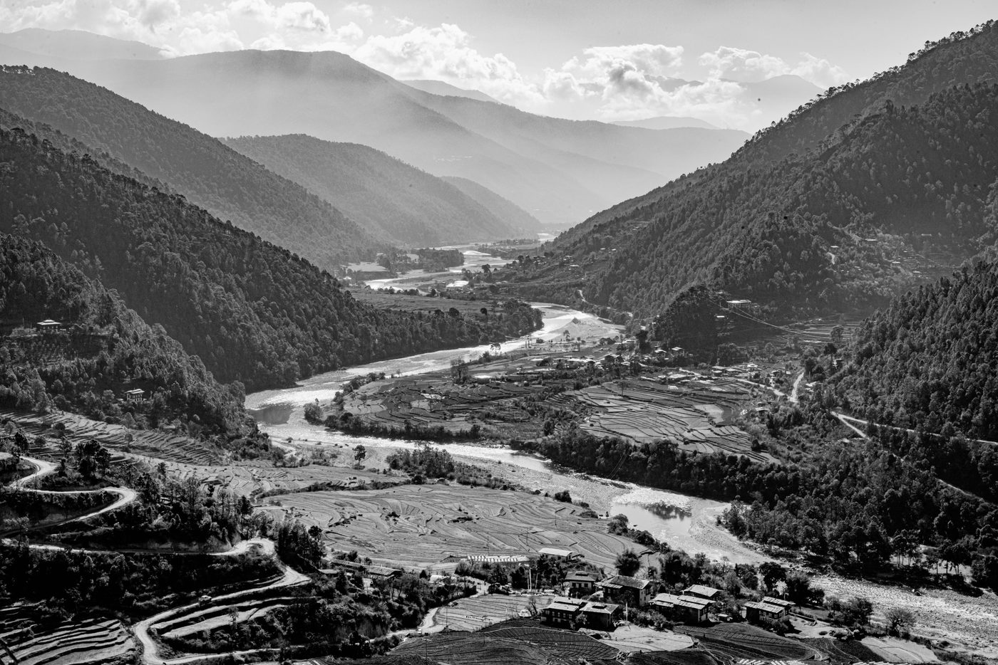 Vale do Butão em preto e branco, rio ao fundo e montanhas em camadas